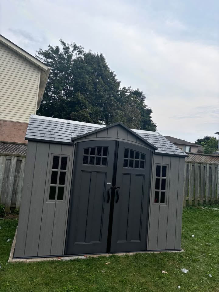 Cabanon gris foncé installé en cour arrière